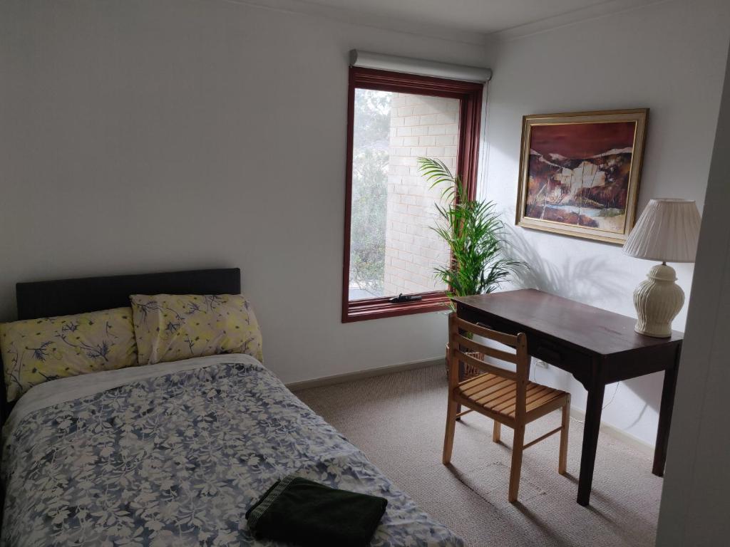 una camera con letto e scrivania con sedia di Attunga Terraces a Phillip