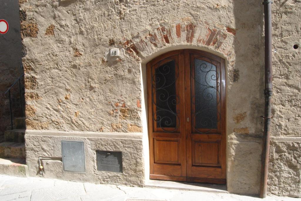 una puerta de madera en el lateral de un edificio de piedra en La Ginestra, en Pienza