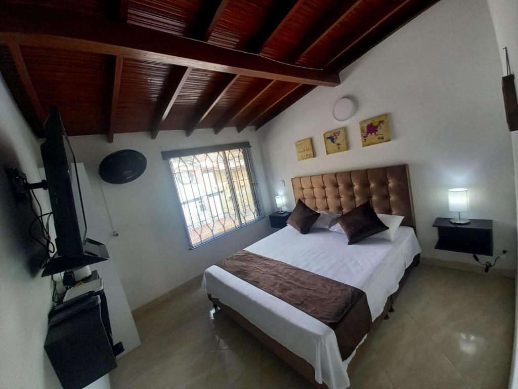 Schlafzimmer mit einem Bett und einem Flachbild-TV in der Unterkunft Hotel boutique San Pablo in Medellín