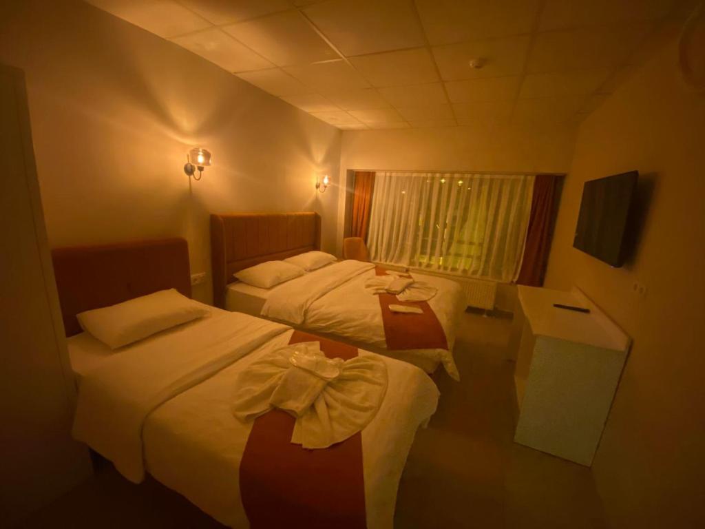 um quarto de hotel com duas camas e uma janela em Kadıköy Bull Hotel em Istambul
