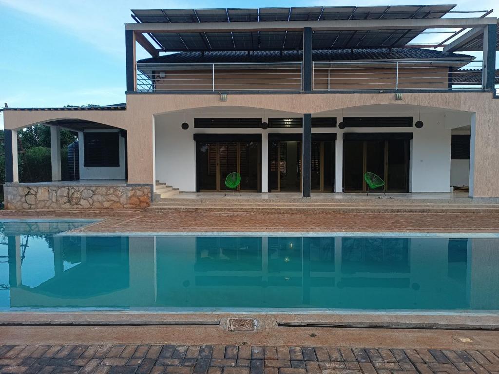 una casa con piscina frente a ella en Grand Grove Villa en Jinja