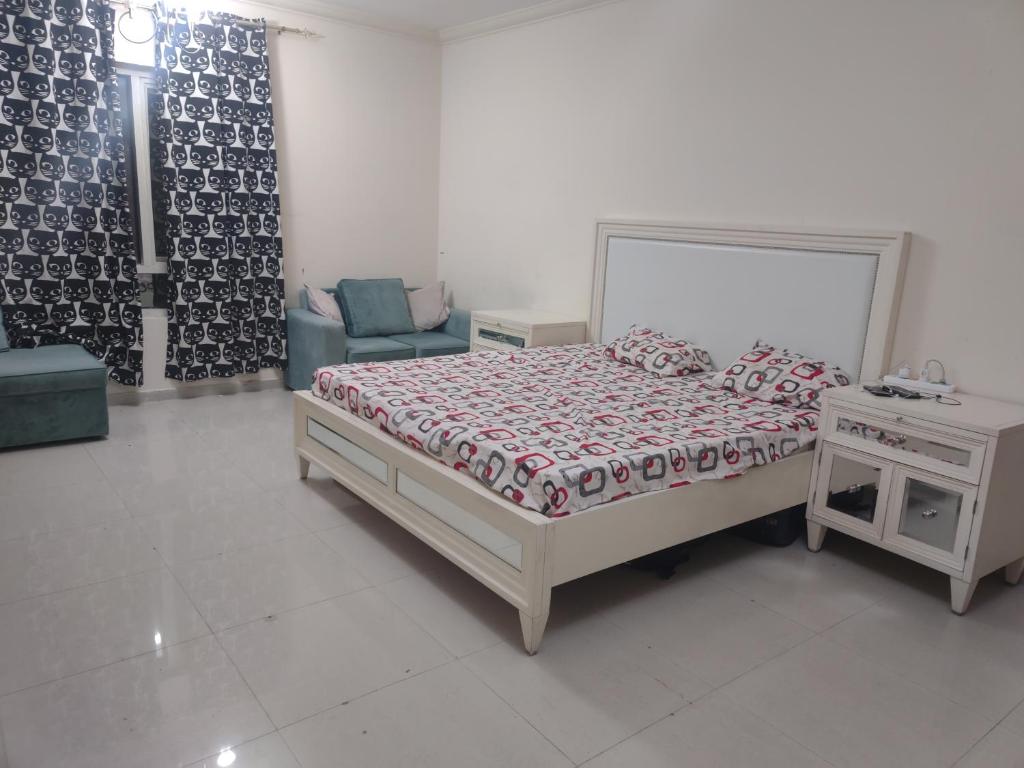 um quarto com uma cama, uma mesa e uma cadeira em Biggest Room in Sharjah em Sharjah
