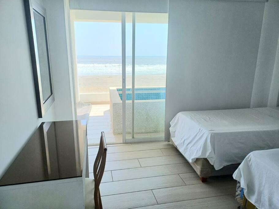 1 dormitorio con cama y vistas a la playa en 202 Urban Beach, en Lurín