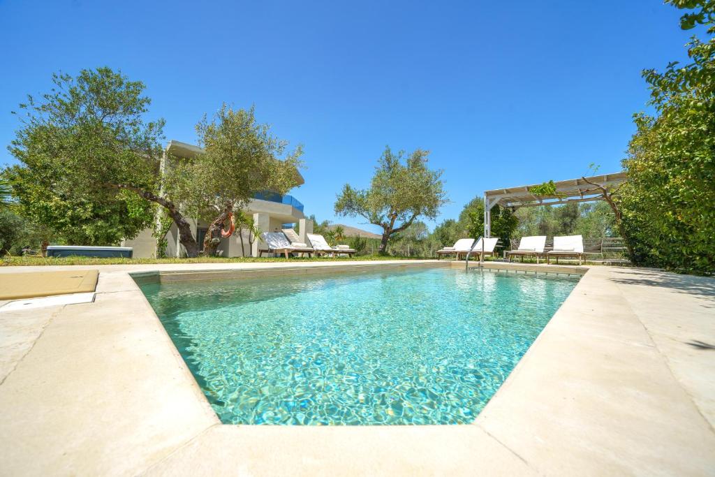 a swimming pool with blue water in a house at Villa Marian with Private Swimming Pool & Jacuzzi in Georgioupolis
