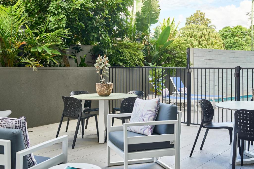 a patio with tables and chairs and a table and chairs at Quest Cannon Hill in Brisbane