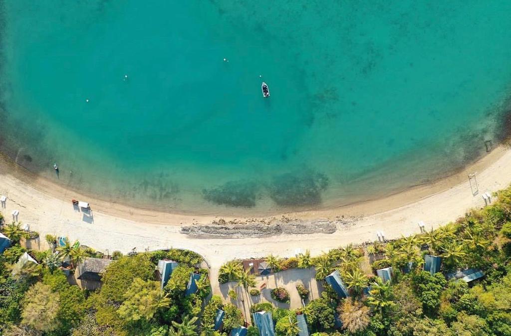 eine Aussicht über den Strand mit einem Boot im Wasser in der Unterkunft Palm Bay Resort in Long Island