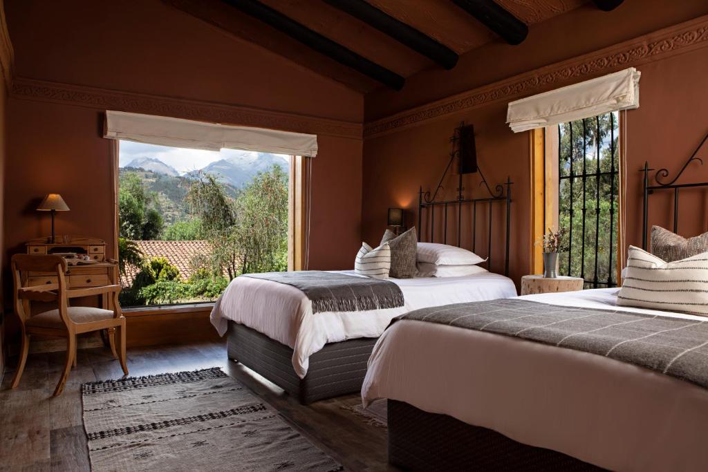 a bedroom with two beds and a large window at Cuesta Serena Boutique Hotel in Huaraz
