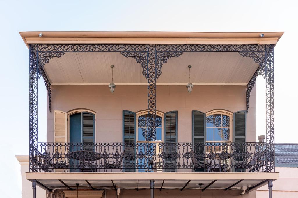 een sierlijk balkon van een gebouw met stoelen erop bij St. Philip Manor French Quarter in New Orleans