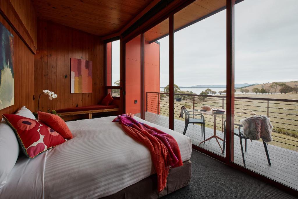 a bedroom with a large bed and a large window at Iron Creek Bay Estate in Sorell