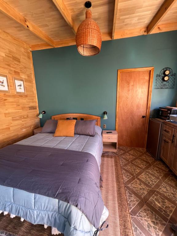 een slaapkamer met een groot bed in een kamer bij Siempre Verde in Puerto Tranquilo