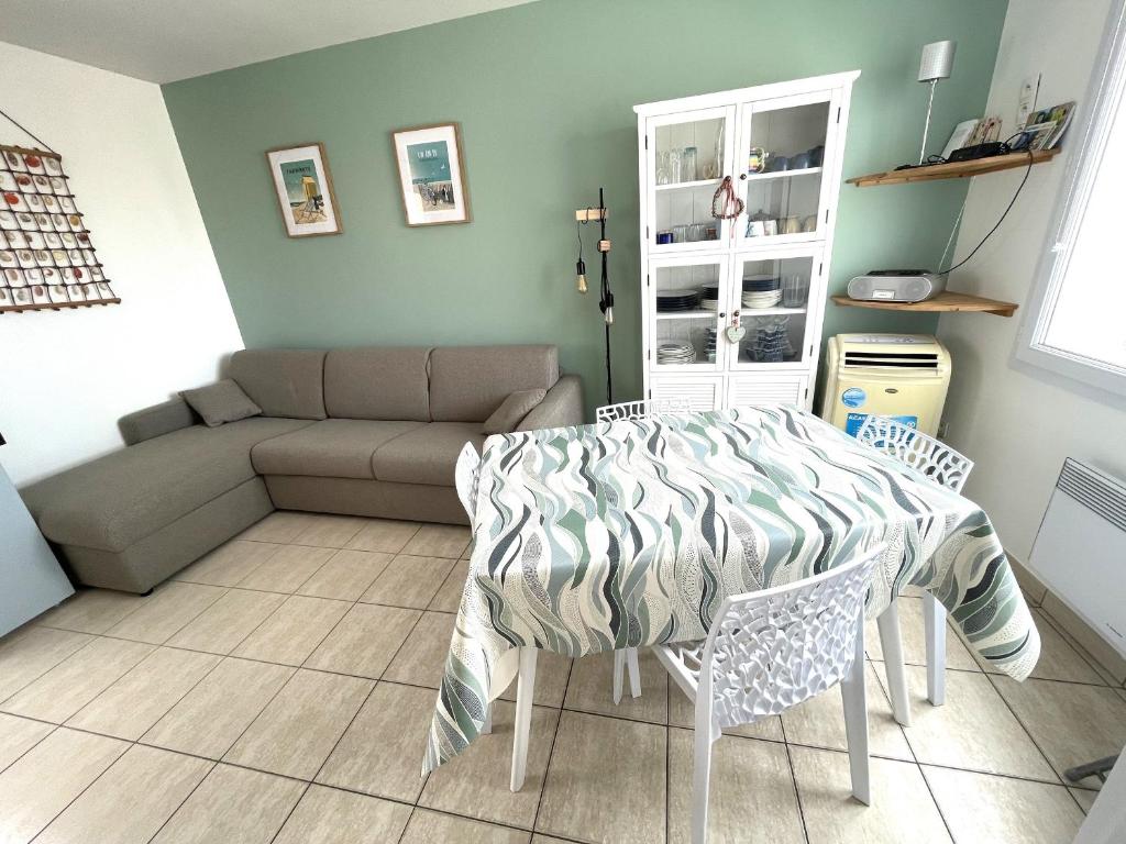 a living room with a table and a couch at Maison proche plage et commerces à La Tranche-sur-Mer - FR-1-22-256 in La Tranche-sur-Mer