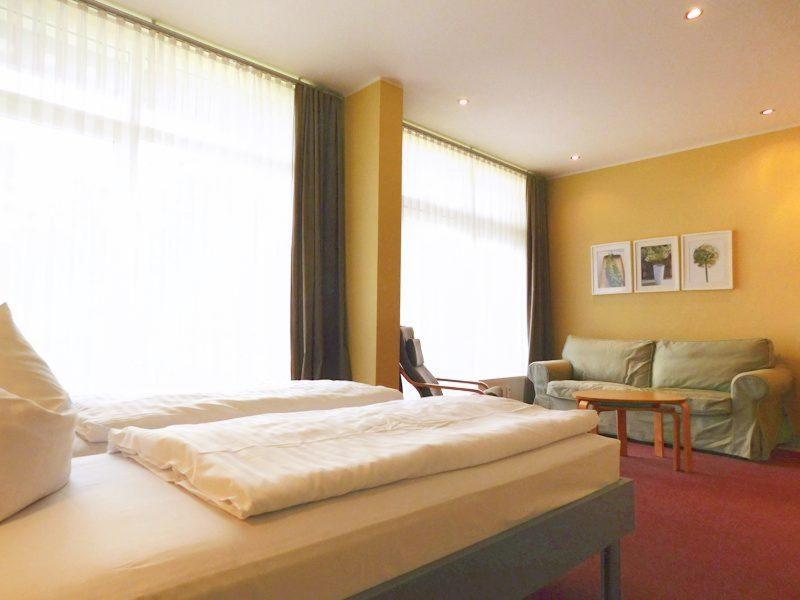 a bedroom with a large bed and a couch at Strandläufer Classic 108 in Granzow