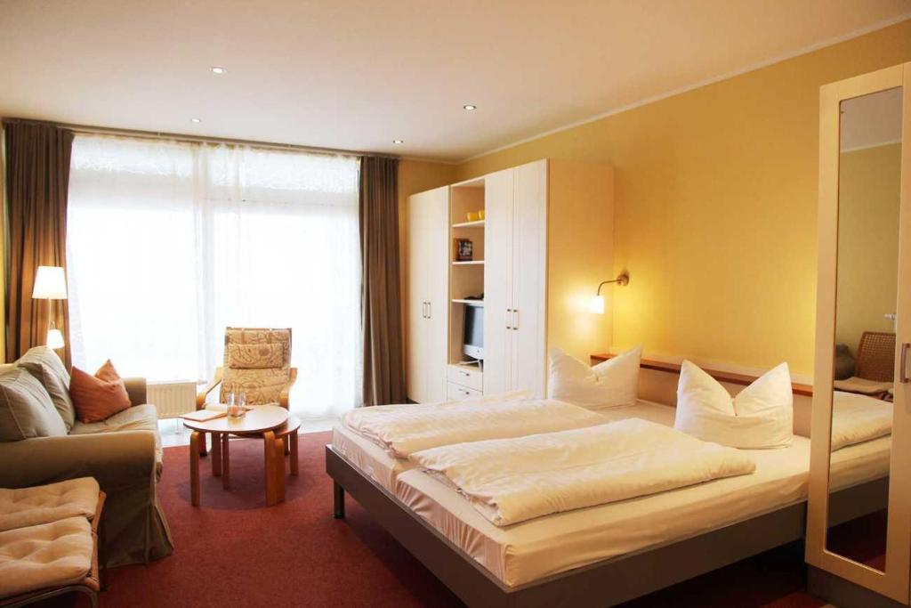a hotel room with a large bed and a couch at Strandläufer Classic 215 in Granzow