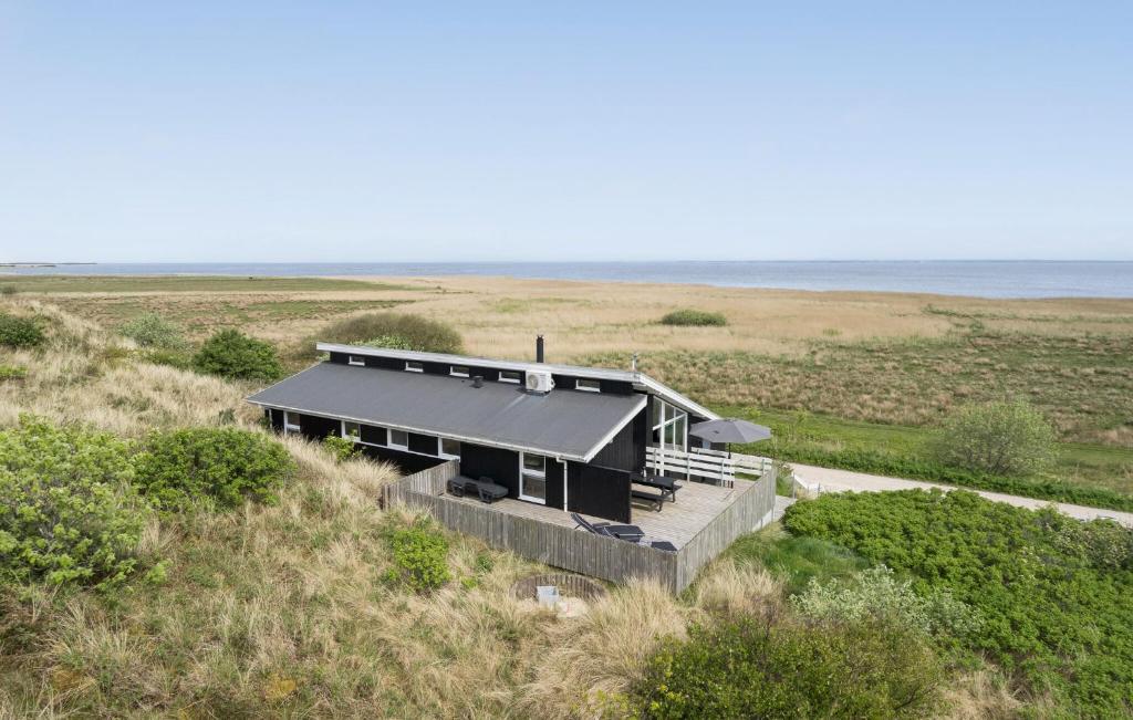 HavrvigにあるNice Home In Hvide Sande With Saunaの海辺の黒屋根の家