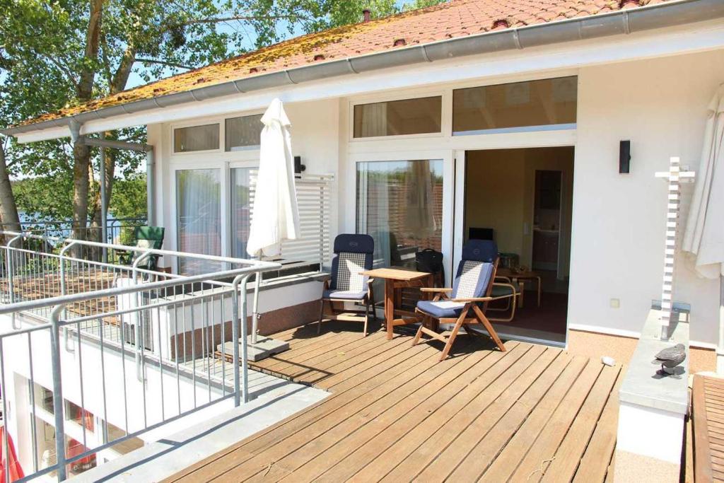 a house with a deck with chairs and a table at Schneeeule 209 in Granzow