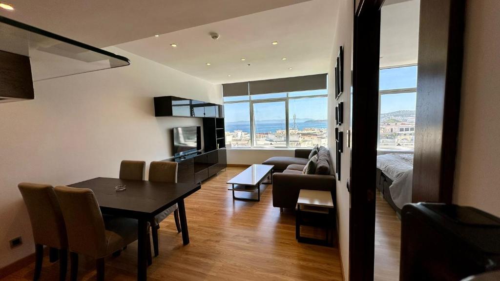 a living room with a dining room table and a room with a couch at hilton apartement families in Tangier