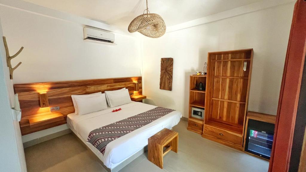 um quarto com uma cama e uma cabeceira em madeira em Marygio Gili Resort em Gili Trawangan