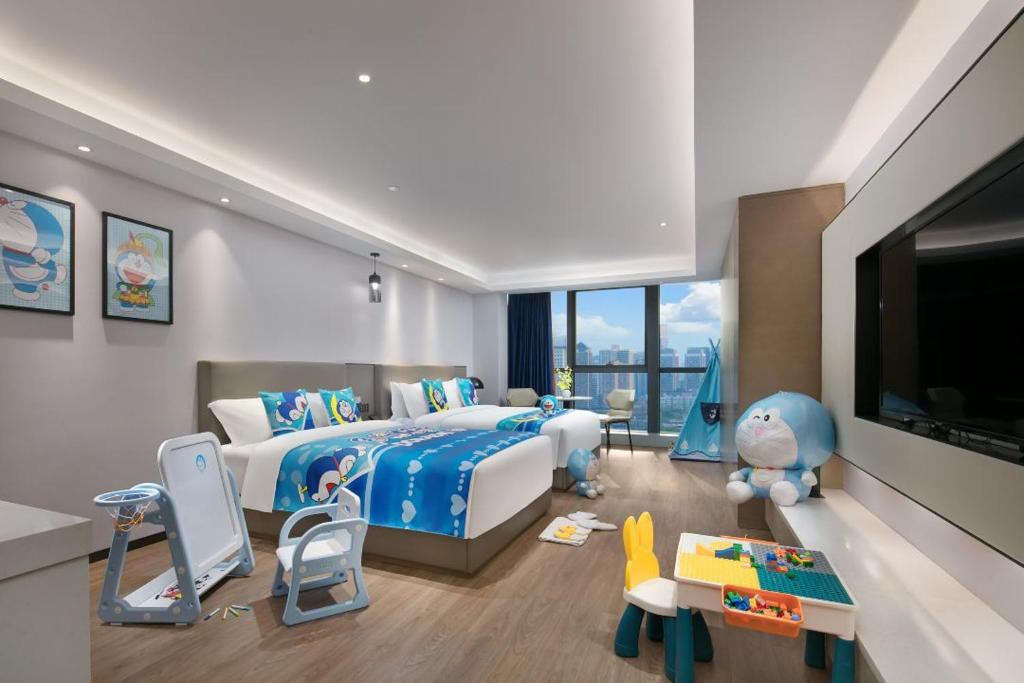 a bedroom with a bed and a tv and toys at Changsha Zealandia Serviced Apartment in Changsha