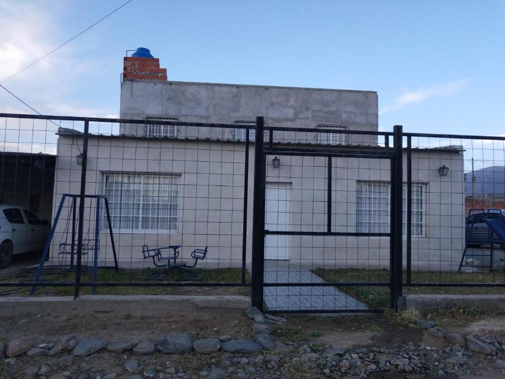 einen Zaun mit einer Bank vor einem Gebäude in der Unterkunft Hospedaje Parano in Amaichá del Valle
