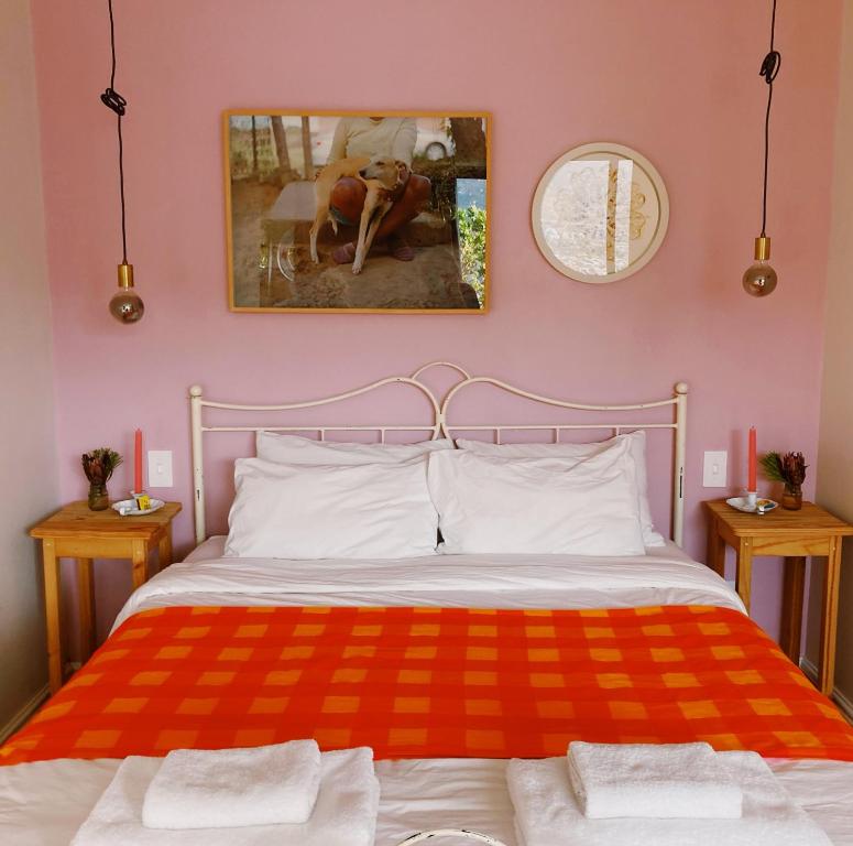 a bedroom with a bed with a red and orange blanket at The Sugarbush in Cape Town