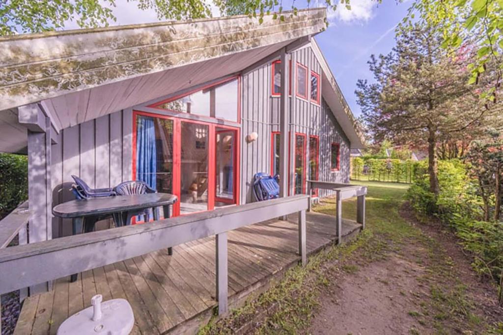 ein kleines Haus mit einer Veranda und einer Terrasse in der Unterkunft Wildgans 81 in Mirow