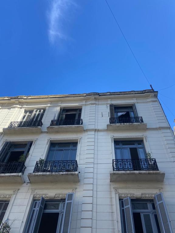 a tall white building with windows and balconies at Hostel Miraflores in Buenos Aires