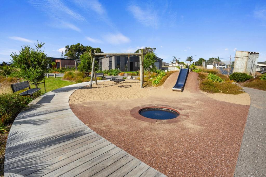a park with a playground with a swing at Modern Family Bach - Waihi Beach Holiday Home in Waihi