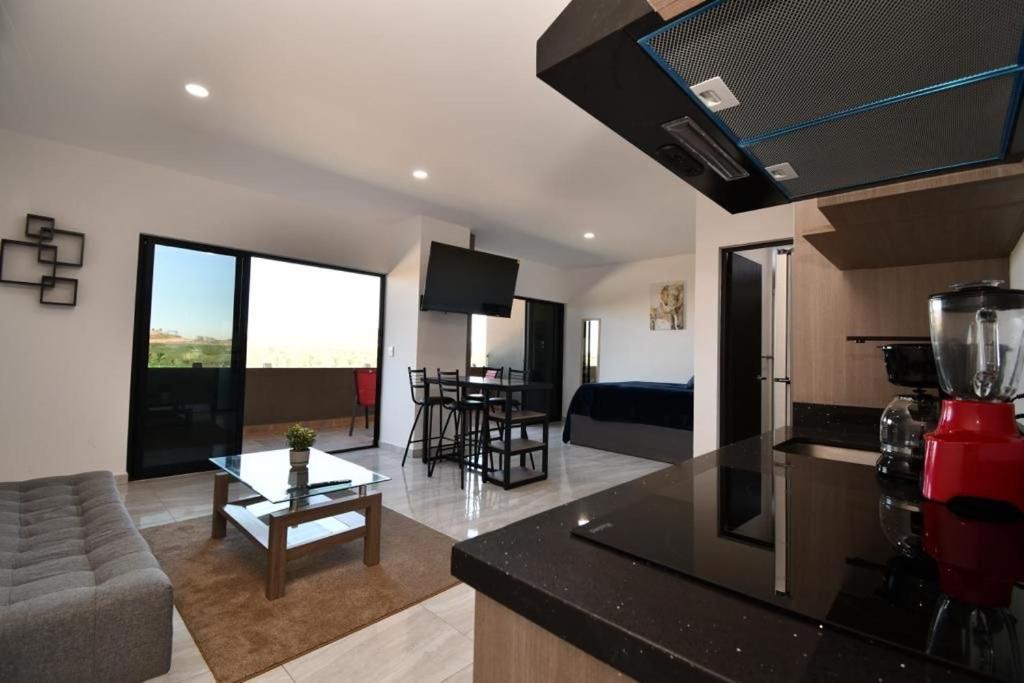 ein Wohnzimmer mit einer Küche und ein Wohnzimmer mit einem Sofa in der Unterkunft Loft de lujo con 9 albercas y vistas al campo de golf in Mazatlán