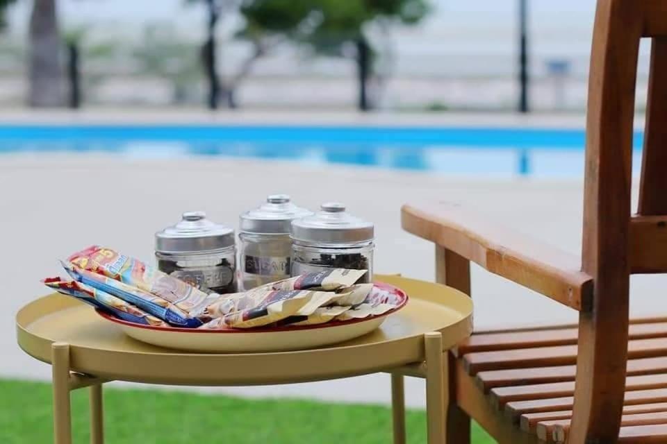 un plateau de bouteilles d'eau sur une table à côté d'un banc dans l'établissement Visas Seaview villa บ้านวิเศษ Pranburi, à Ban Pru Yai