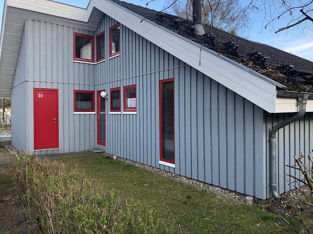 a gray house with red doors and windows at Wildgans 41 in Mirow