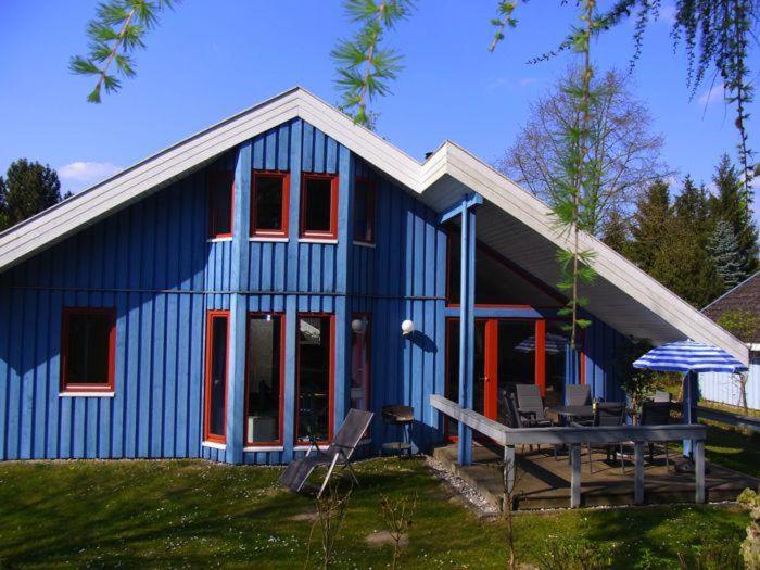 a blue house with a picnic table in front of it at Wildgans 42 in Mirow