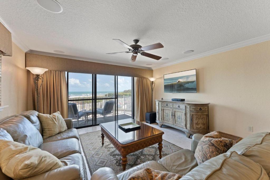 uma sala de estar com um sofá e uma mesa em Ola Grande 218 em Cocoa Beach