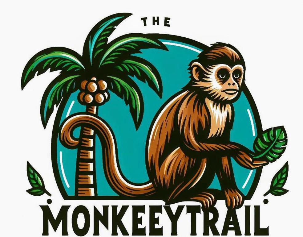 a monkey is standing next to a palm tree at The Monkey Trail Hostel in Drake