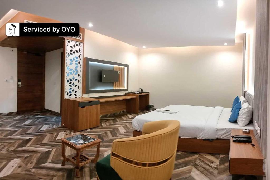 um quarto de hotel com uma cama e uma televisão de ecrã plano em Townhouse OAK Hotel Hardik Palace Sector 116 em Noida