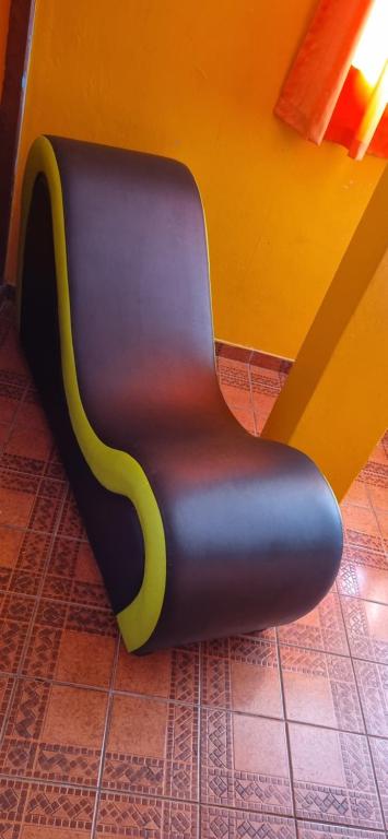a black and yellow chair sitting in a room at Hostal Chavin in Lima