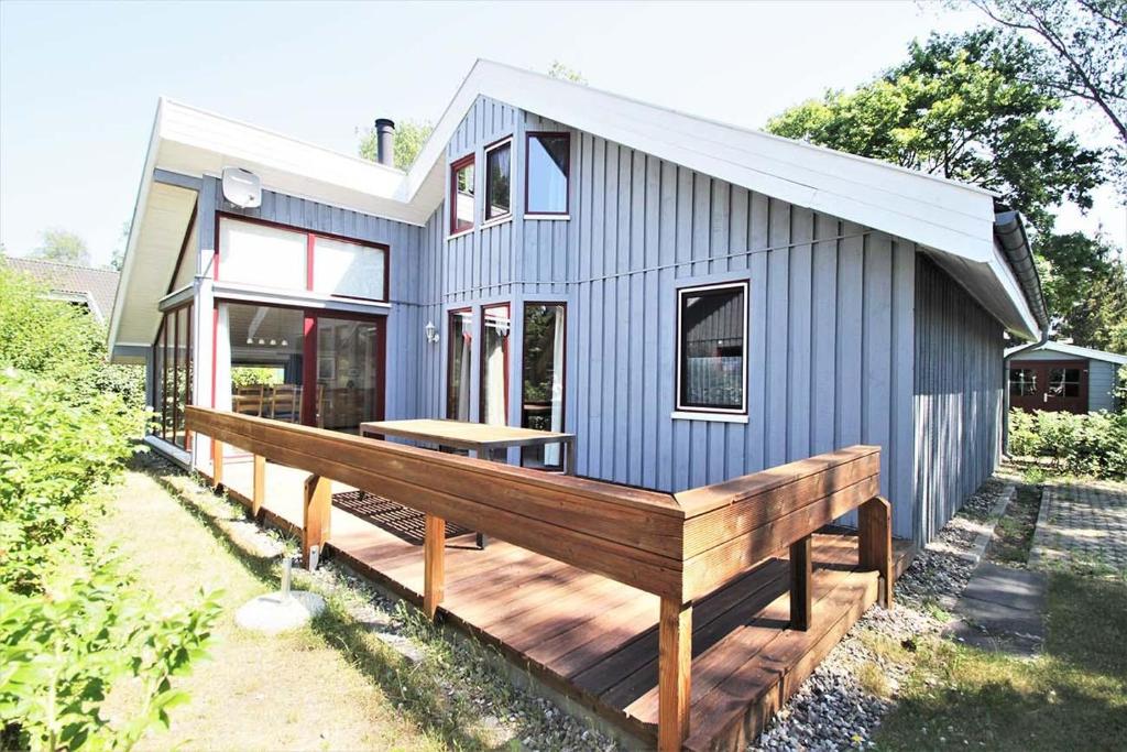 a blue tiny house with a wooden deck at Wildgans 267 in Mirow