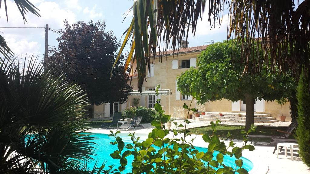 a swimming pool in front of a building at Les Abris de Saint Sulpice - Saint-Émilion in Saint-Sulpice-de-Faleyrens