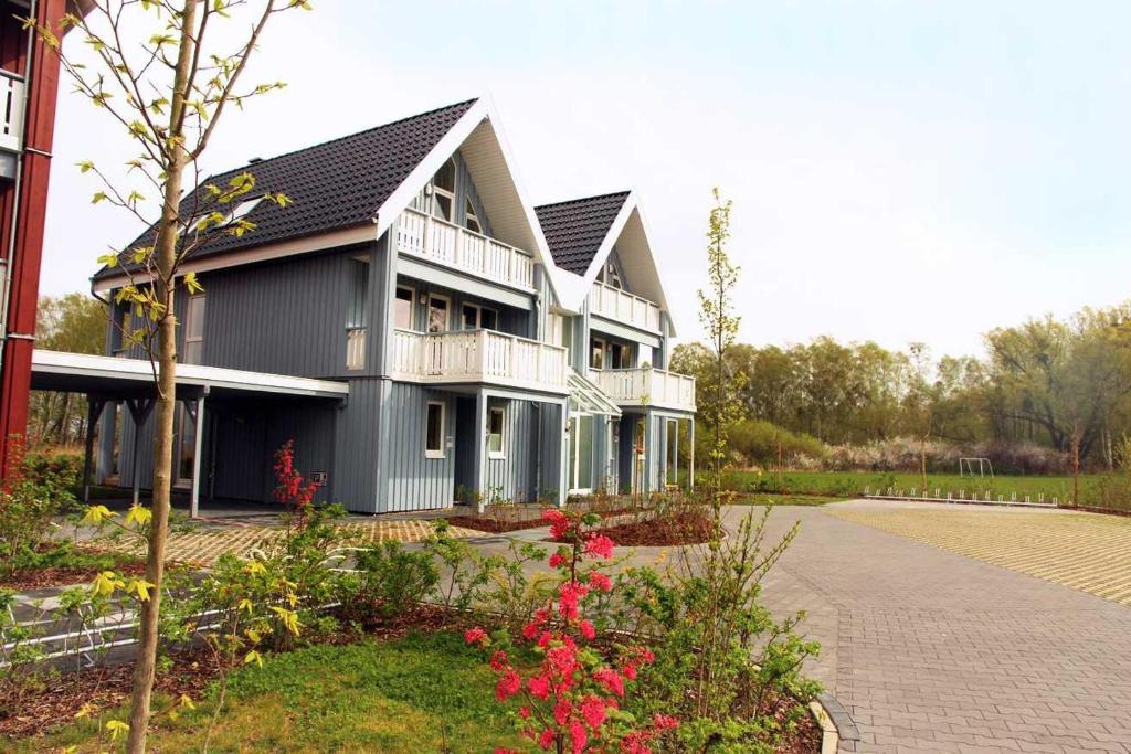 a large house with a courtyard with flowers at Kapitänsdeck 534 in Rechlin
