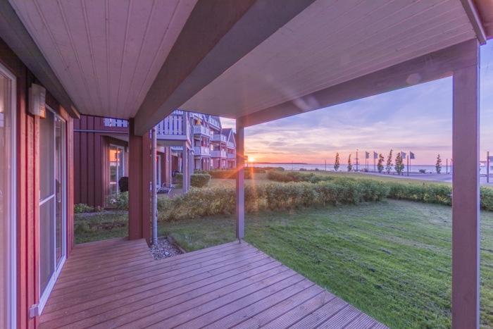 eine Veranda eines Hauses mit Blick auf den Strand in der Unterkunft Gartendeck 431 in Rechlin