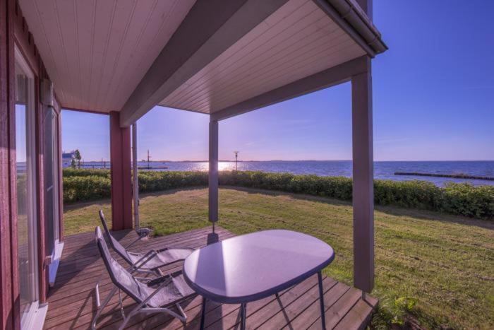 a table and chairs on a porch with the ocean at Gartendeck 501 in Rechlin