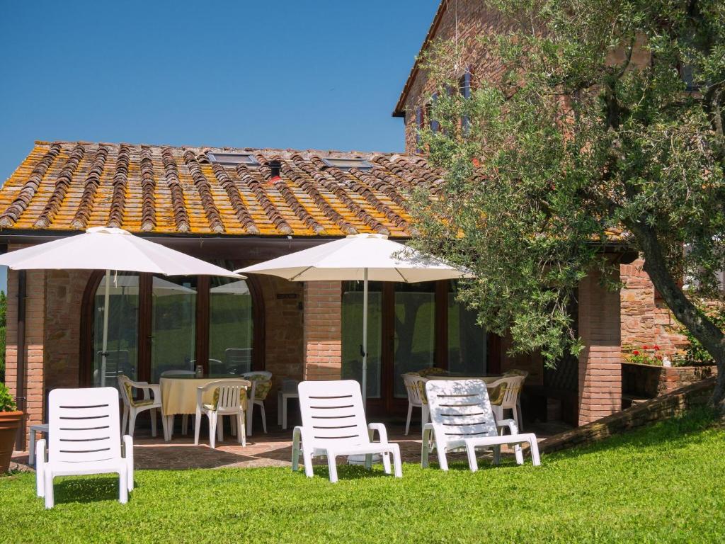 grupa białych krzeseł i parasoli przed domem w obiekcie With pool and air conditioning w mieście Montaione