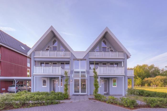 a large white house with a red at Gartendeck 532 in Rechlin