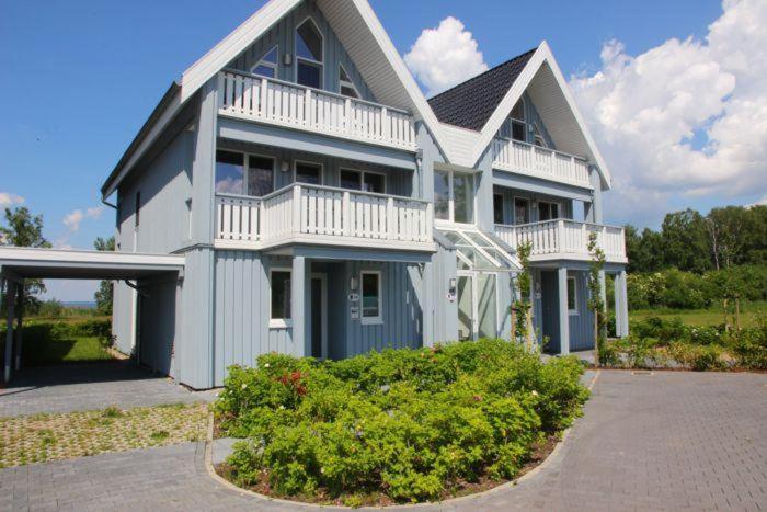 a large white house with a porch and balcony at Gartendeck 531 in Rechlin
