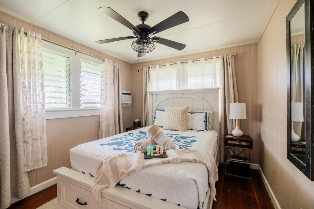 a bedroom with a bed with a ceiling fan at Hale Leilani - Hilo 3BR cold AC in Hilo