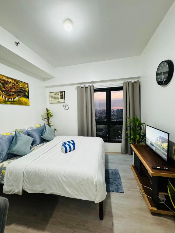 a bedroom with a bed and a couch and a television at Vinia Infinity Studio 1 Near Malls with WiFi and Netflix in Manila