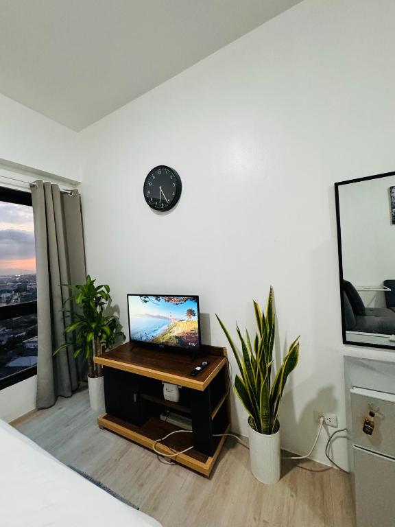 a room with a tv on a table with plants at Vinia Infinity Studio 1 Near Malls with WiFi and Netflix in Manila