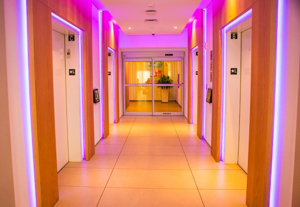 um corredor de um edifício com luzes rosa e roxa em Miami Sunset City View 1809 em Miami