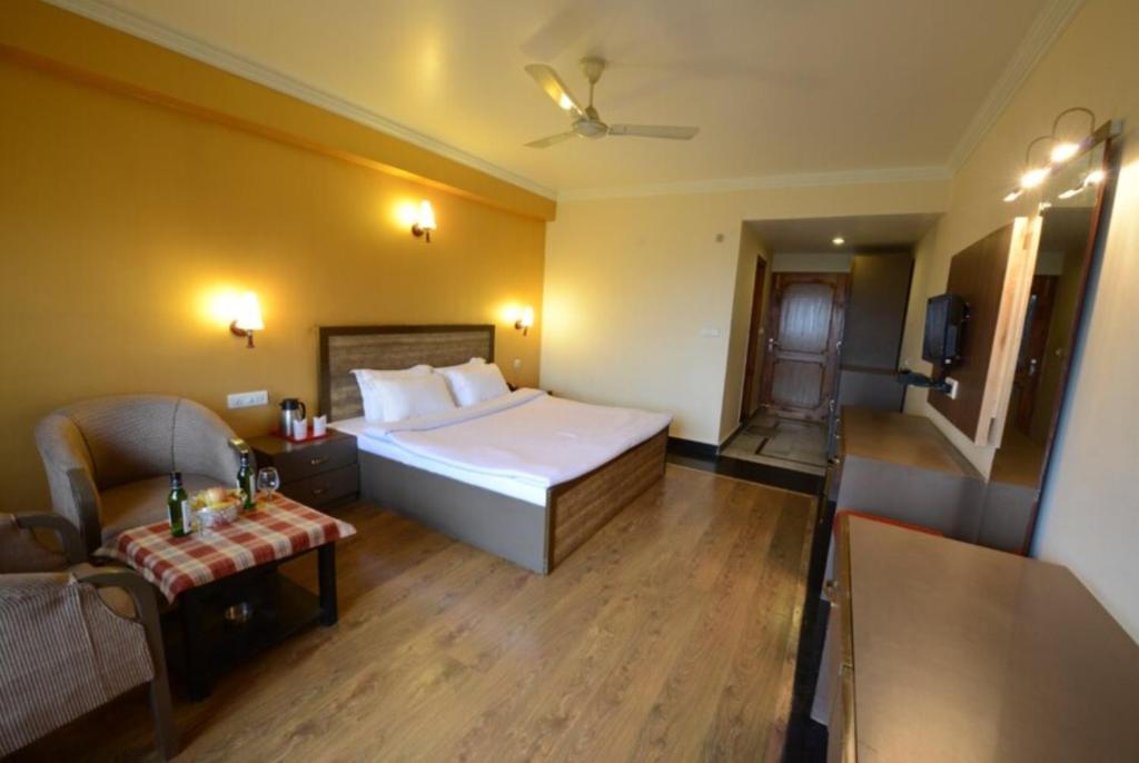 Habitación de hotel con cama y sofá en Goroomgo Park Paradise Manali - Elevator Lift & Parking Facilities en Manāli