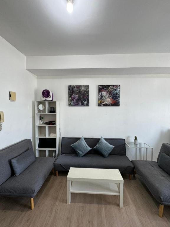 a living room with two couches and a coffee table at Vinia Infinity Studio 1 Near Malls with WiFi and Netflix in Manila