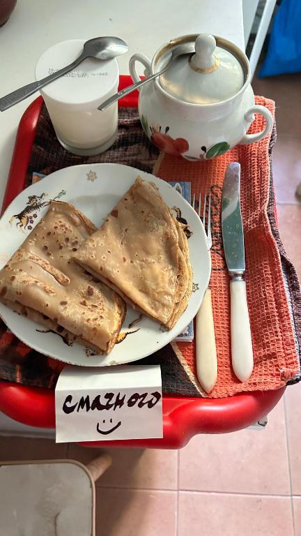 a plate of food on a red tray with a tea pot at Очень Уютная, Тихая, Эко Комната С Видом На Сад in Vinnytsya